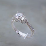 18 Karat White Gold 2 Baguettes=.14 44 Round=.41 Total Weight GHVS12 Cubic Zirconia Center