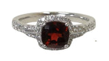 A vibrant 6mm cushion-cut garnet blazes at the center, encircled by a halo of dazzling diamonds.